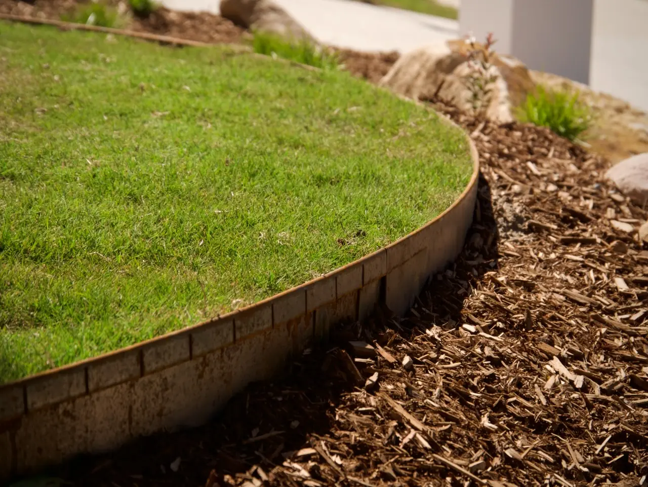 Mown lawn running up to a cleanly edged garden bed